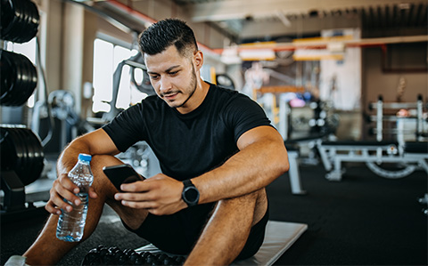 Male looking at phone in gym