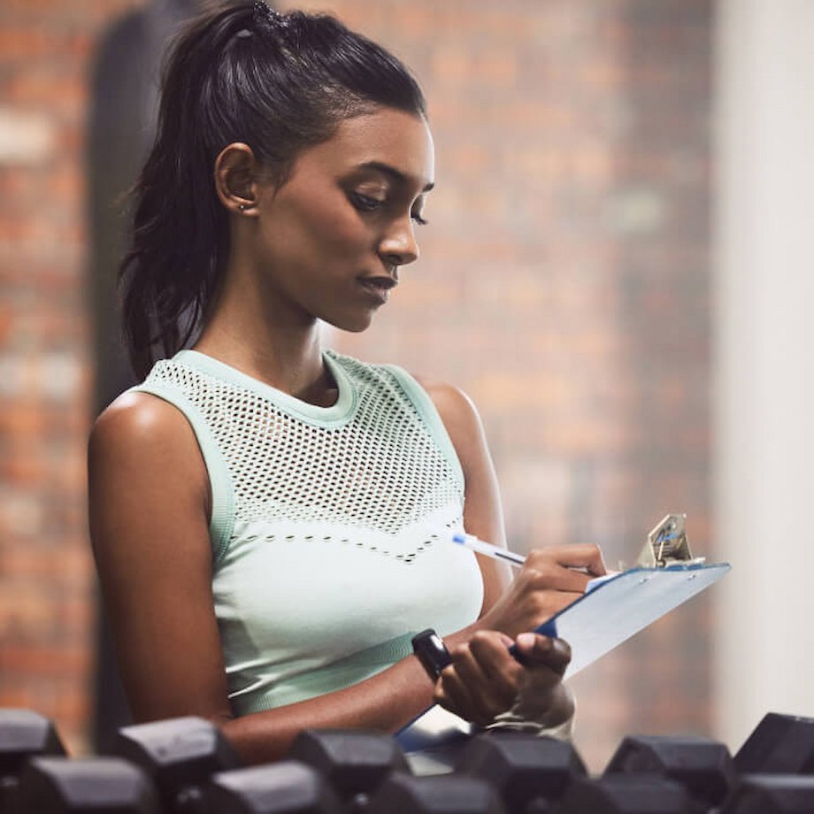 Female trainer writing on her clipboard