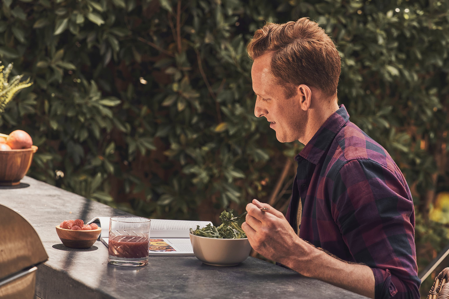 A man eats a salad outdoors