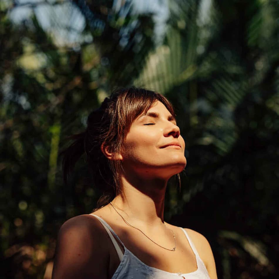 A woman standing outside enjoying the sun light