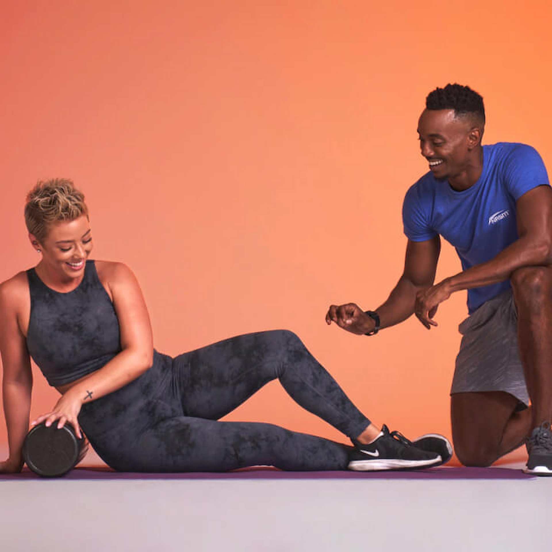 A male trainer helping a female client