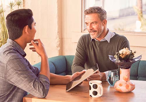 wellness coach and client talking at a table