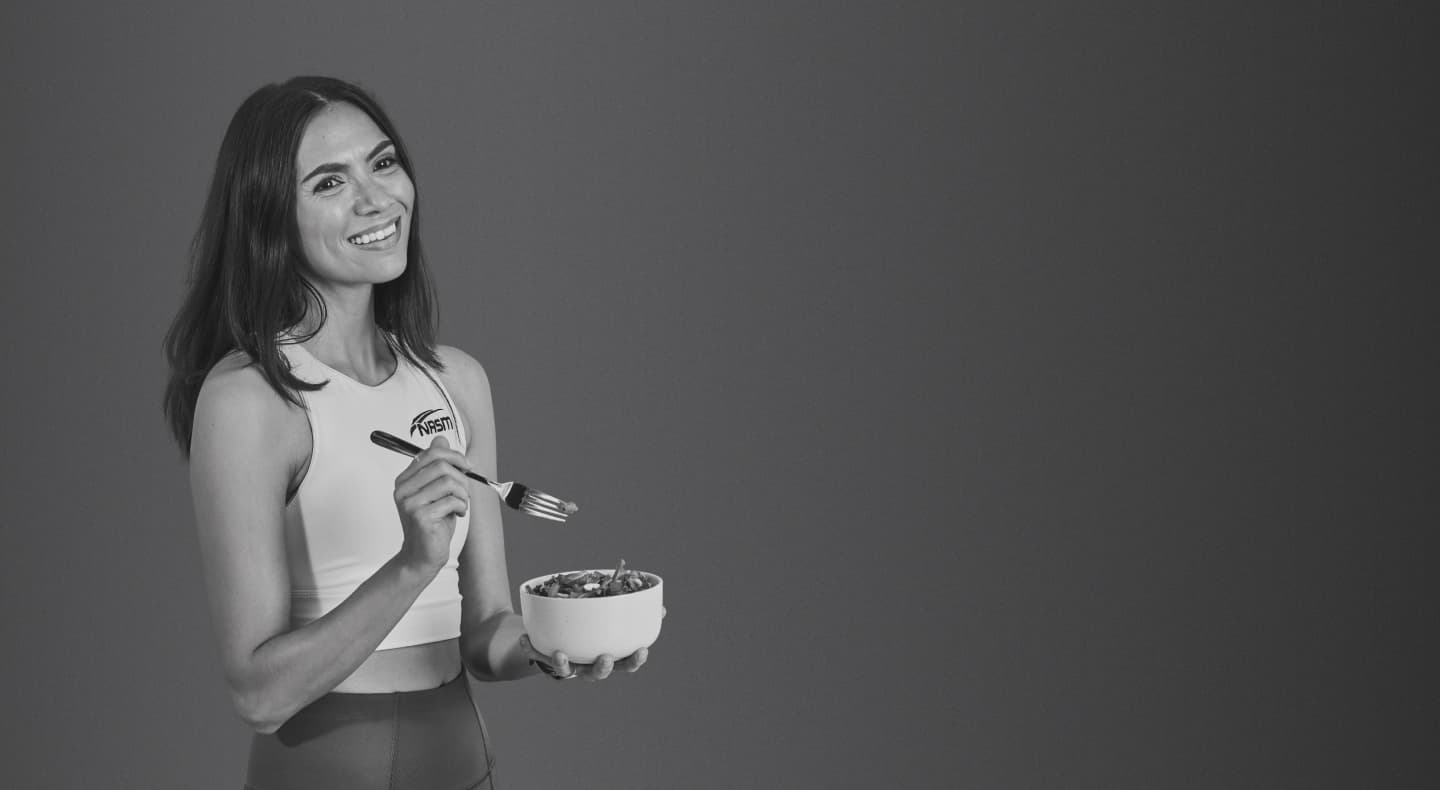 Woman smiling and eating salad