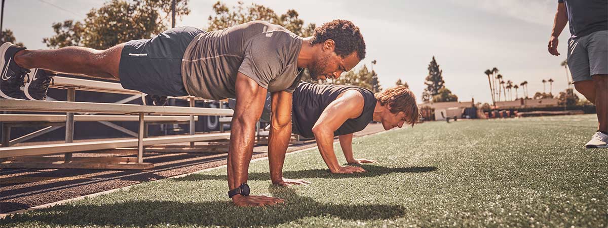 NASM trainer assisting athletes with outdoor workout