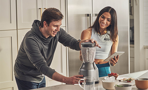 Nutrition coach helping client making smoothie