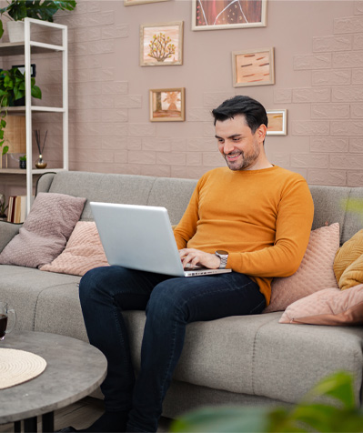 A male on his laptop on a couch