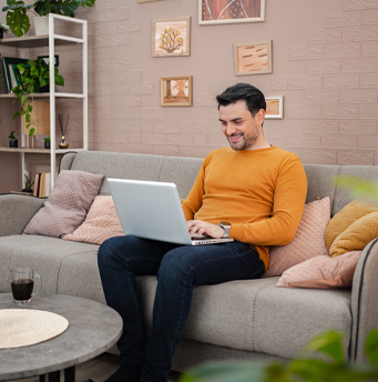 A male on his laptop on a couch