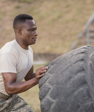 A male soldier flipping a tire