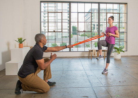 corrective exercise specialist training client with band