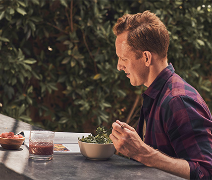 male outside eating a salad