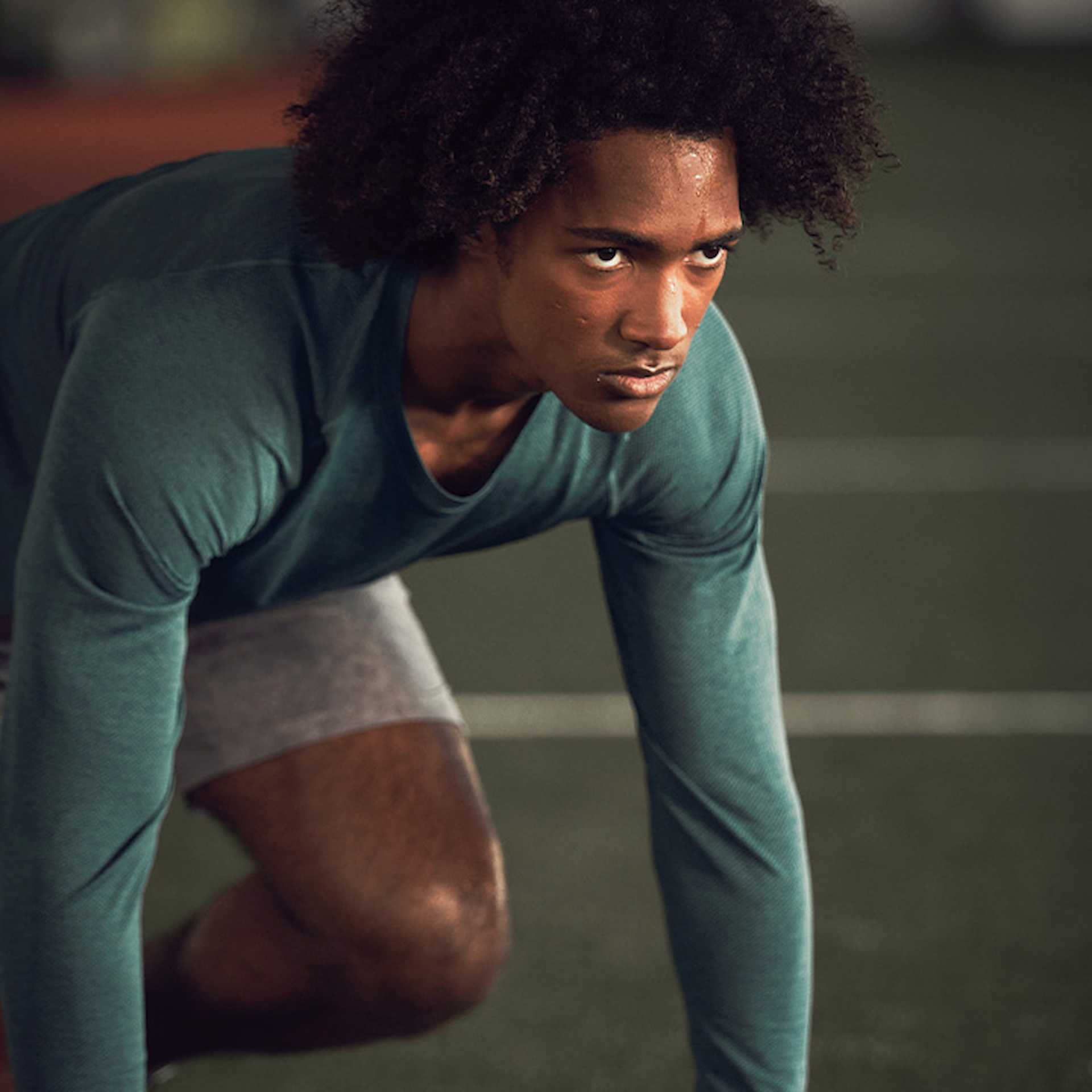 Male athlete about to start a workout on turf