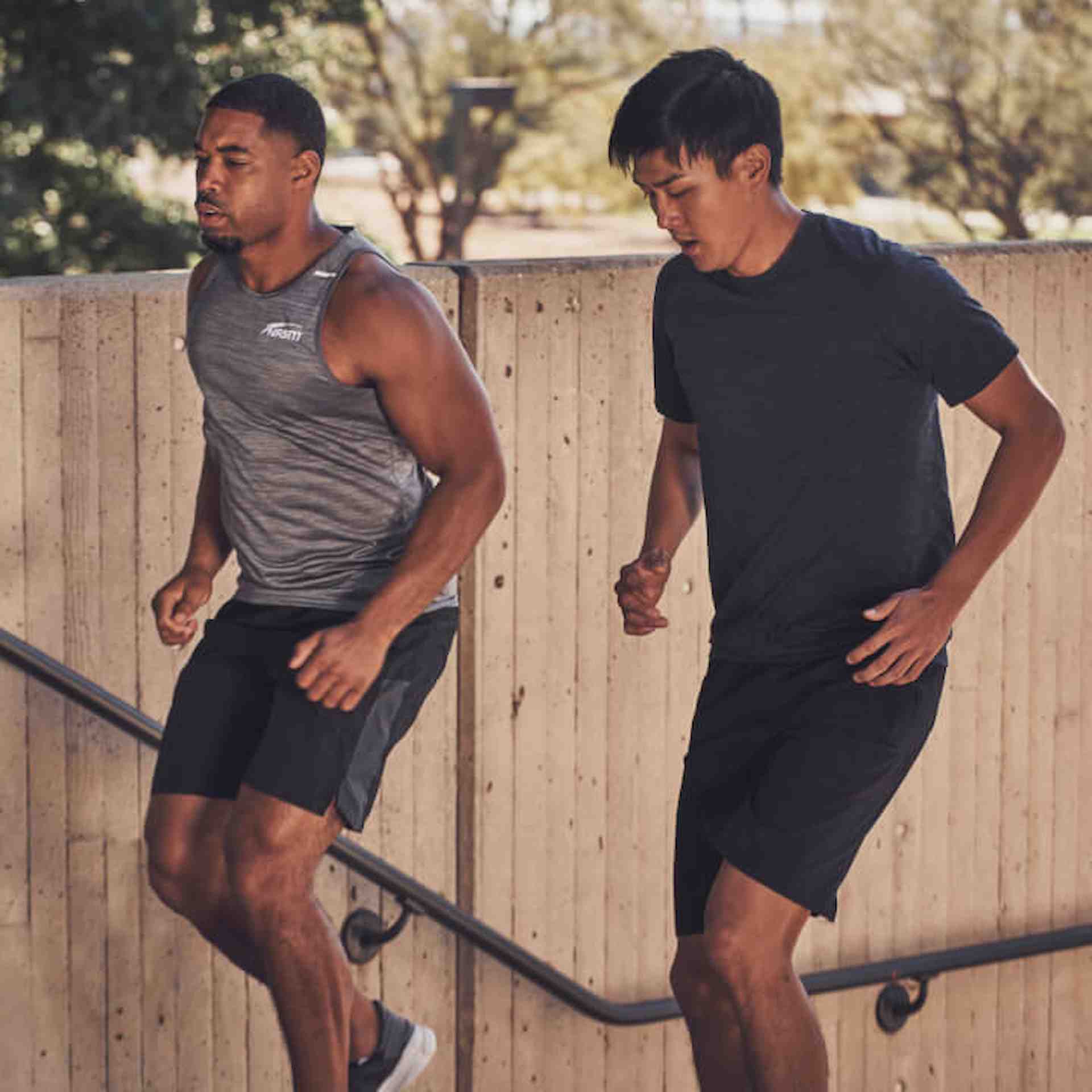 Two women wearing workout gear are standing and talking