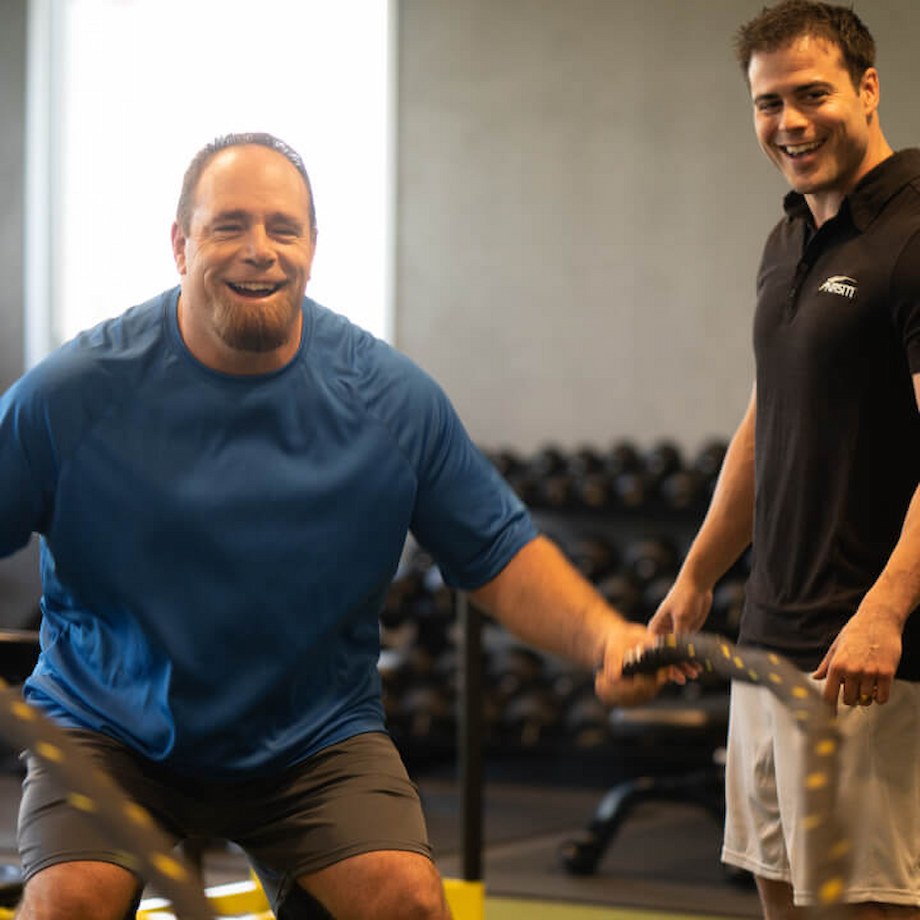 A male trainer helping out a male client