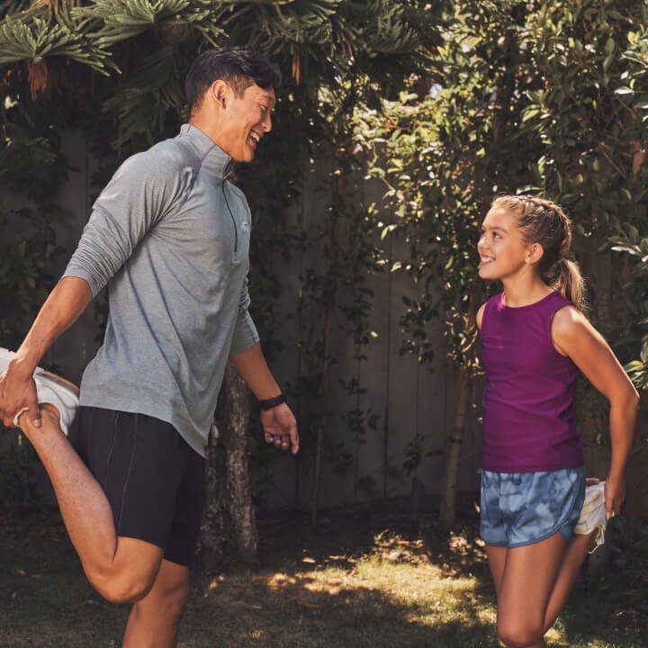 A man and little girl stretching outside